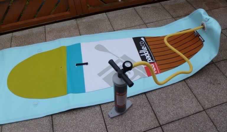 Vyfouknutý nafukovací paddleboard s ruční pumpou a hadicí.