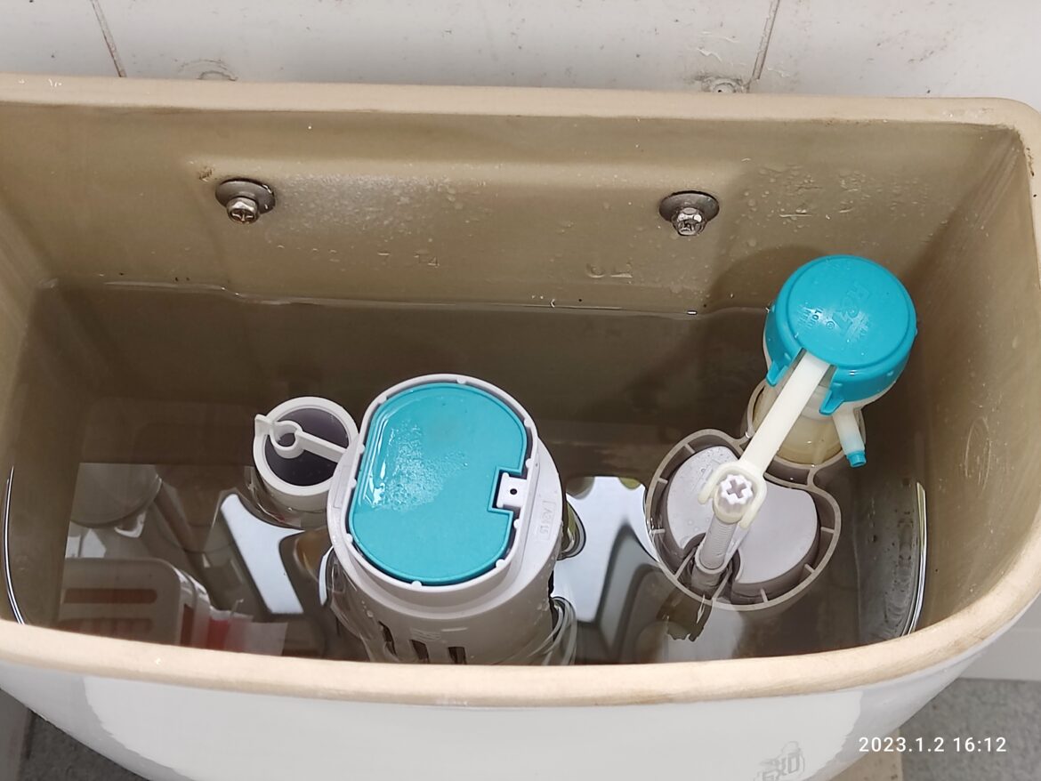 Otevřená splachovací nádržka WC s napouštěcím a vypouštěcím ventilem.