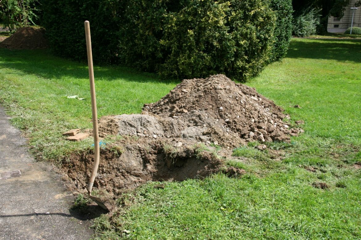 Rýč zapíchnutý do odkryté zahradní půdy