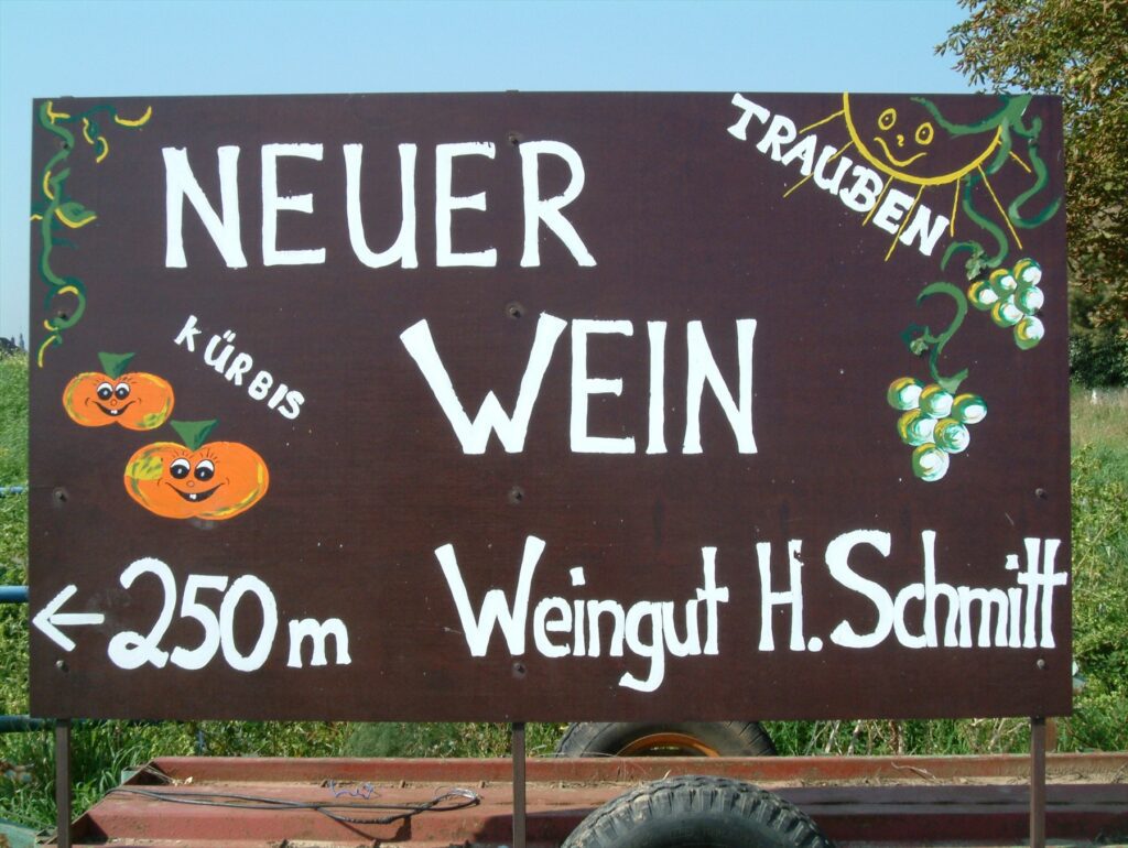 Tabule s nápisem Neuer Wein a směrovkou k vinařství v Dirmsteinu