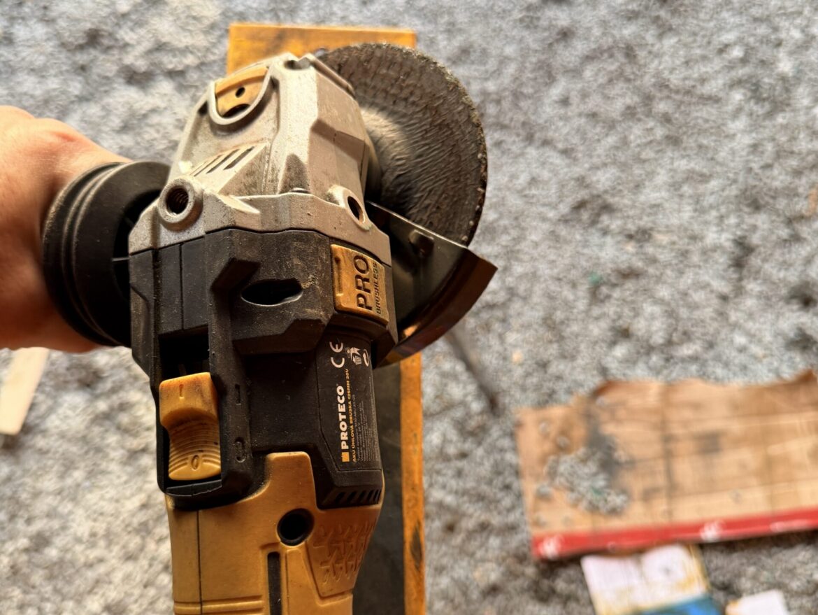 Detail úhlové brusky Proteco v ruce s nasazeným brusným kotoučem 125 mm připravené k broušení oceli