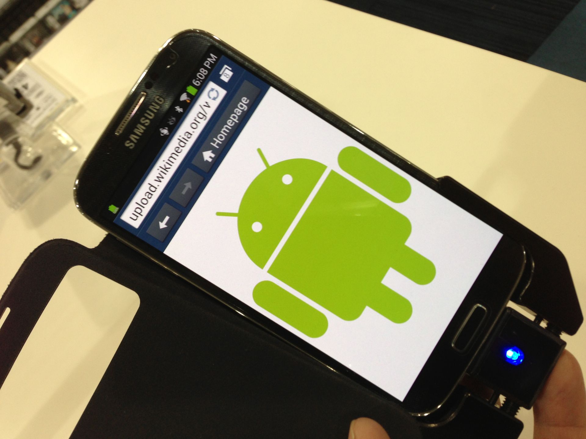 Černý telefon Samsung s postavičkou Androidu na displeji