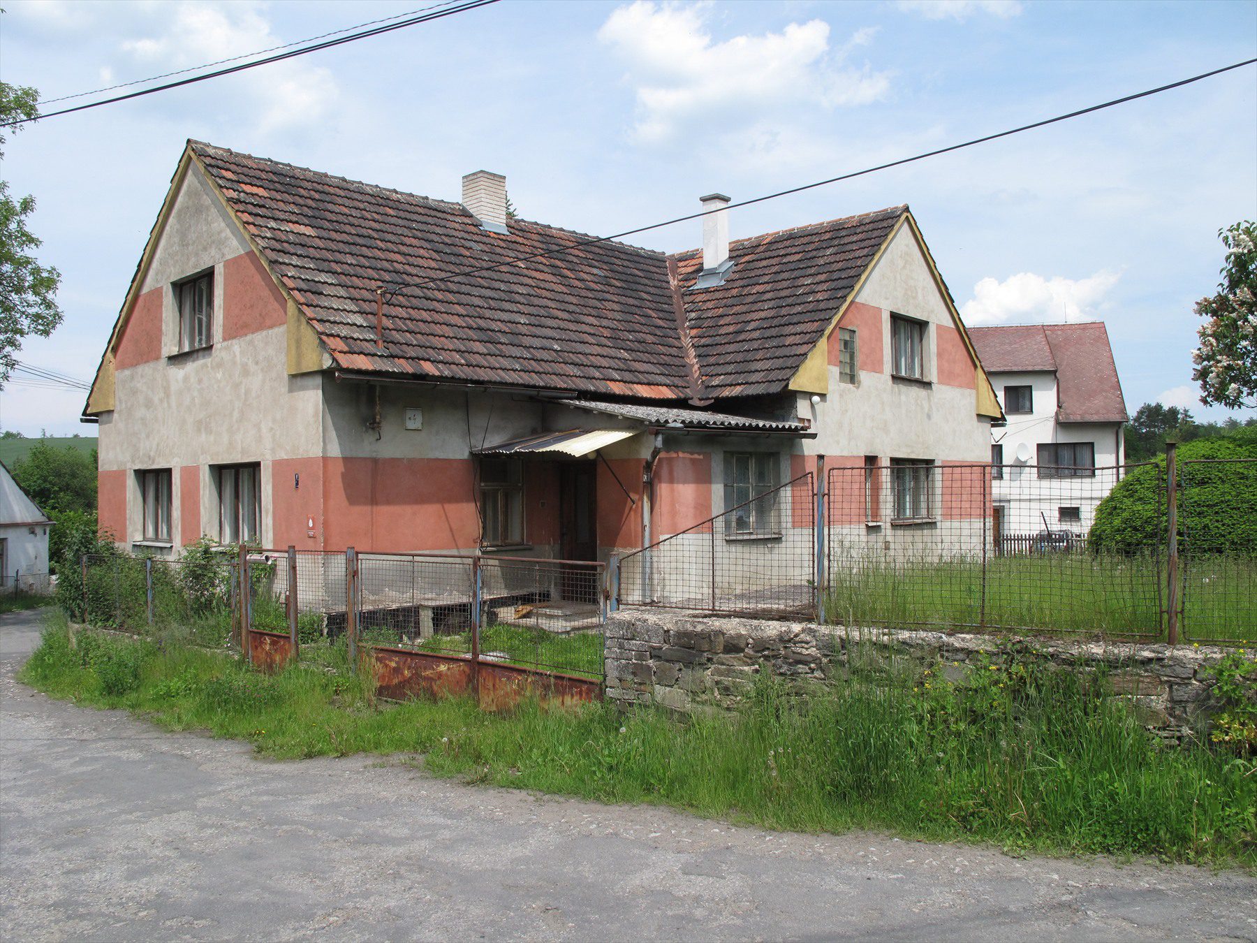 Starší omítaný dům s taškovou střechou a oplocenou zahradou v Bělicích
