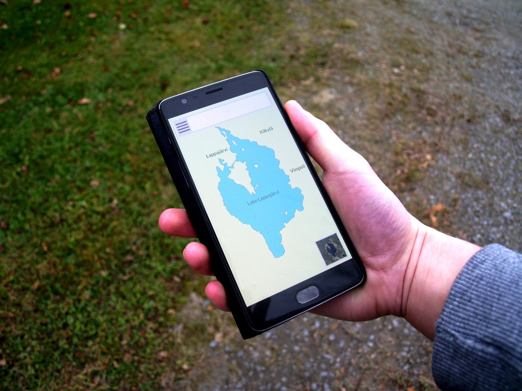 Ruka drží chytrý telefon s otevřenou navigační mapou