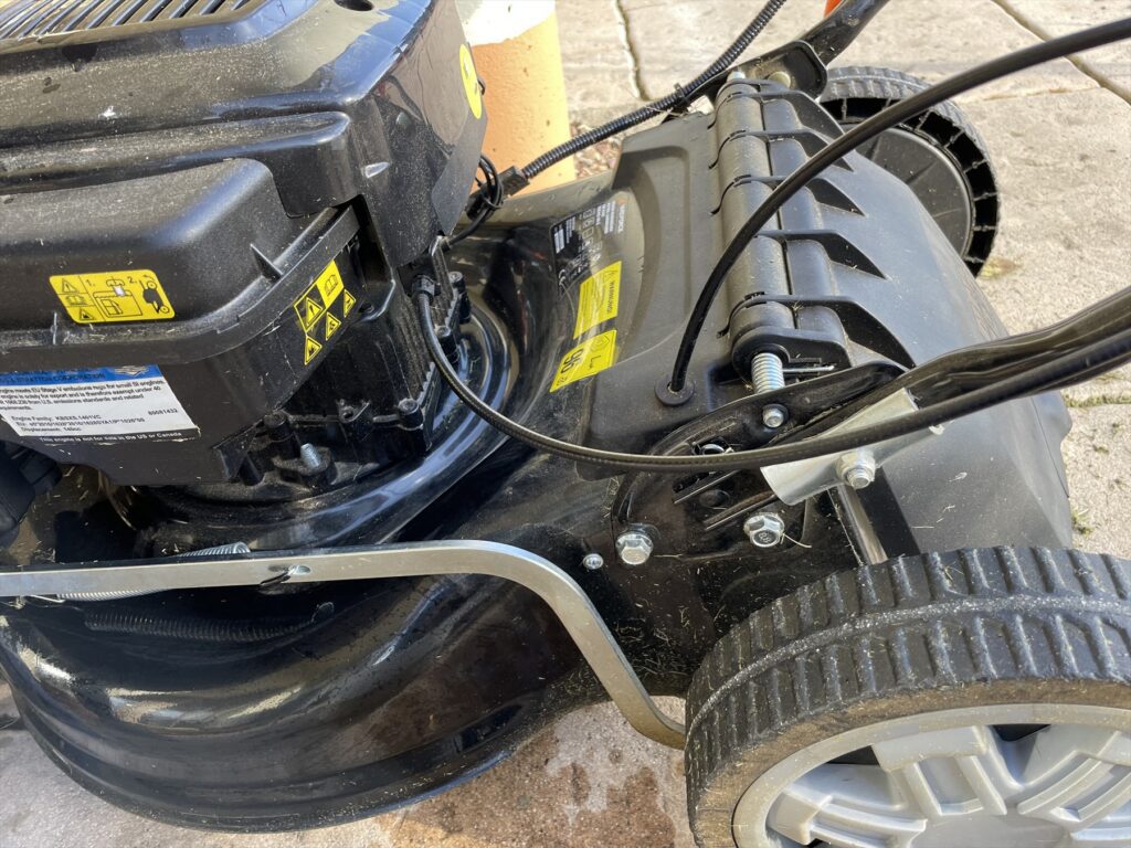 Detail kol, žacího krytu a rukojeti benzínové sekačky.