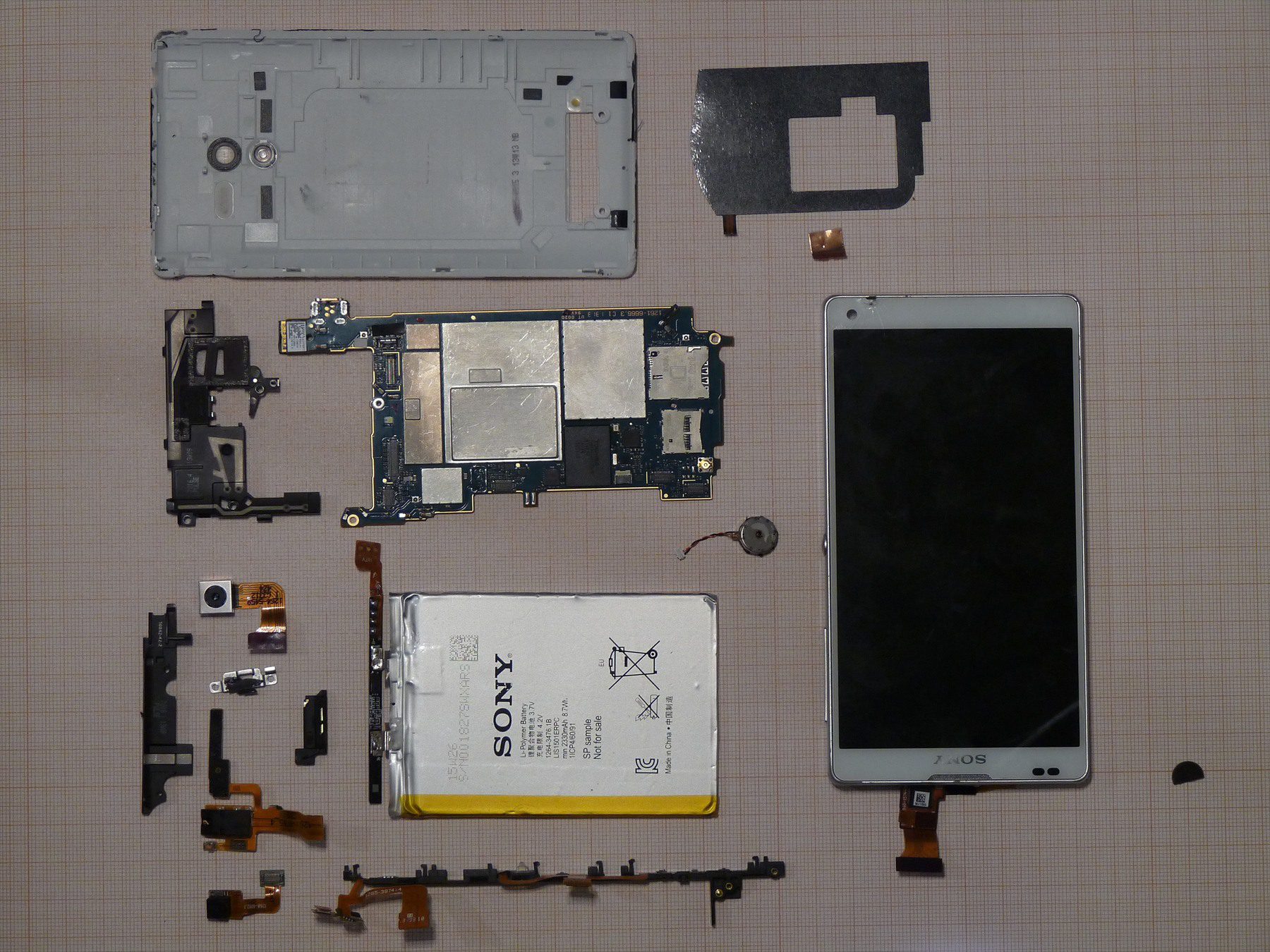 Telefon Sony Xperia rozložený na displej, baterii, základní desku a kryty