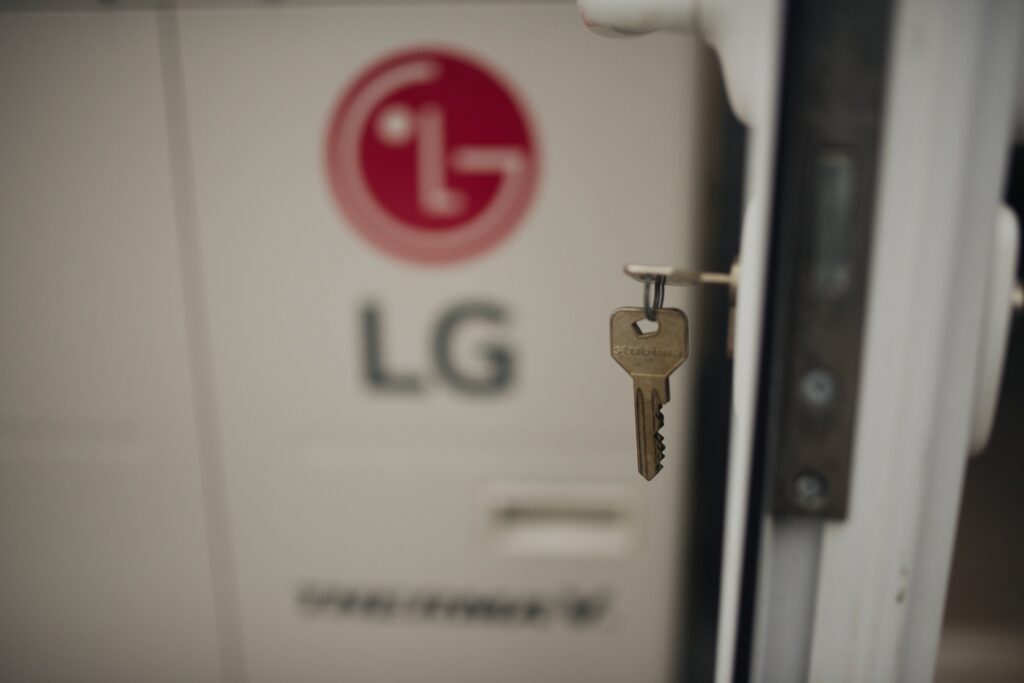 Detailní pohled na kovový klíč zasunutý v cylindrické vložce vchodových dveří