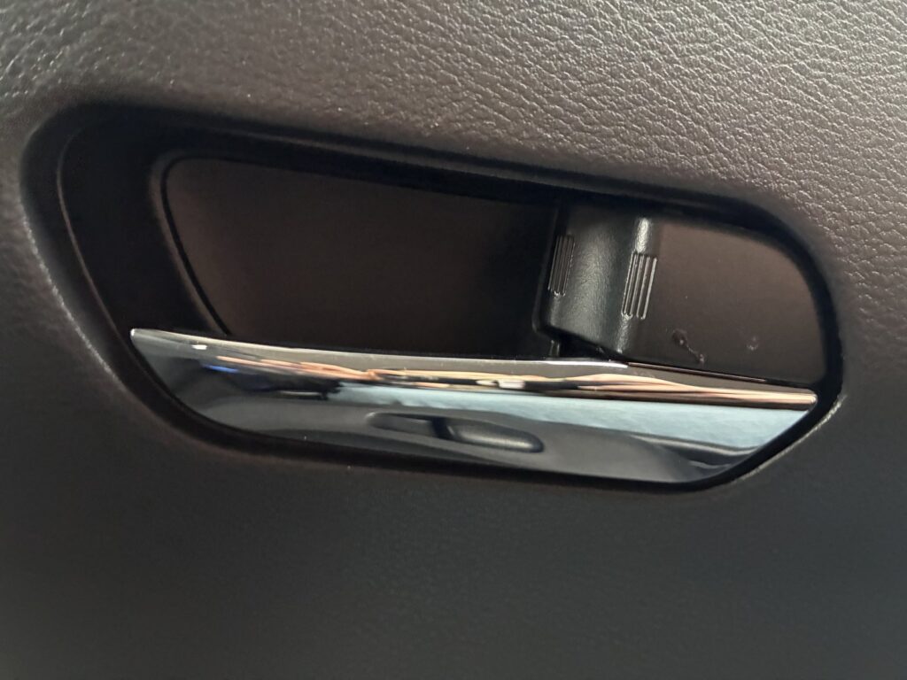 Detail kliky dveří automobilu a zámkového mechanismu.