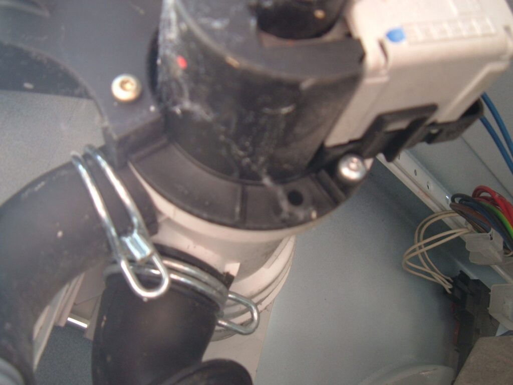Detail vypouštěcího čerpadla automatické pračky s plastovou vrtulkou.